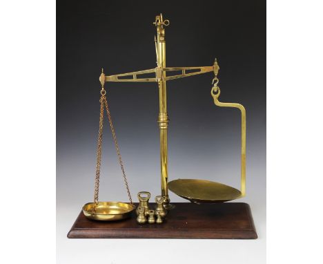 An early 20th century set of Avery balance scales, the polished brass frame mounted on a rectangular mahogany platform base, 
