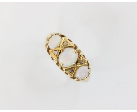 An opal and diamond 18ct gold ring, comprising a central polished oval opal cabochon (measuring 6.1mm x 4.4mm), with a furthe