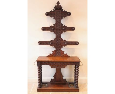 A 17th century style carved oak tree form hall stand, late 19th century, with three graduated branches to both sides upon a r