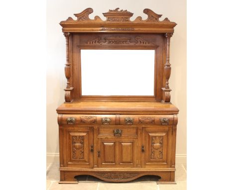 A late Victorian carved oak mirror back sideboard, the high mirror back supported on a pair of carved columns, upon the base 