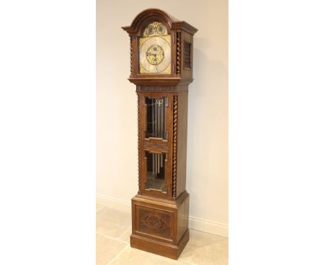 An early 20th century oak cased Westminster chime longcase clock, the arched hood with barley twist pilasters flanking the 33