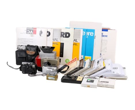 An assortment of cameras and equipment. To include a selection of darkroom paper (opened but resealed with tape), camera manu