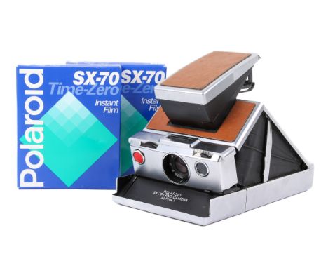A Polaroid SX-70 Land Camera Alpha 1. Chrome and tan covering. Together with two sealed boxes of SX-70 Time-Zero Instant Film