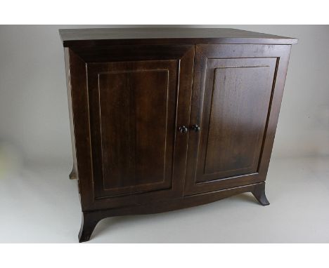 A mahogany collector's tabletop cabinet of twin panel doors enclosing six long drawers, on bracket feet, 46.5cm high