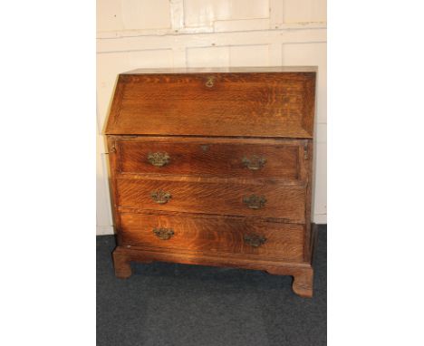 An oak bureau with fall front enclosing small drawers and pigeon holes above three graduated drawers, on bracket feet, 95cm