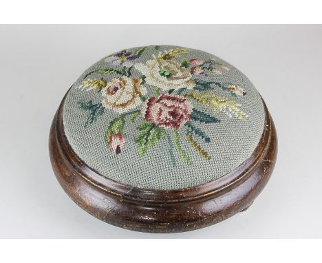 A 19th century oak framed tapestry footstool with floral design, 29cm diameter