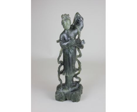 A 20th century Chinese spinach jade figure of a woman with flowing robes holding a rabbit, 30cm high