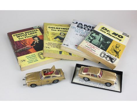 Two Corgi James Bond Aston Martin DB5s in gold, together with four James Bond books by Ian Fleming, Dr No, From Russia with L