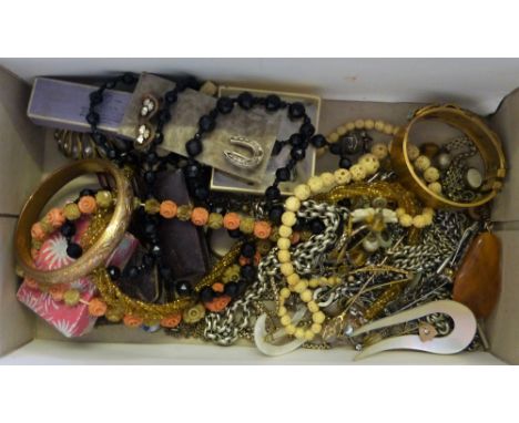 A quantity of costume jewellery to include a Victorian gilt metal bangle and various metal chains