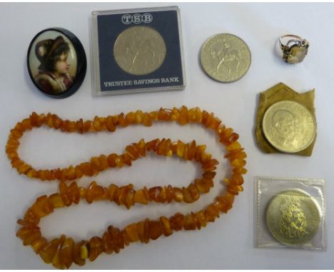 A gold mounted dress ring stamped 585, a portrait brooch, four crowns and an amber bead necklace