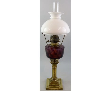 A Victorian table oil lamp with brass stepped square base and short Corinthian column stem, amethyst glass reservoir, duplex 