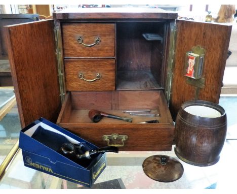 An smoker's oak cabinet in the form of a safe containing a mixing bowl, pipes and lighter