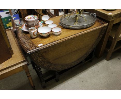 A carved oak barley twist gate leg dining table; a four oak barley twist oak dining chairs; and a pair of oak carver chairs 