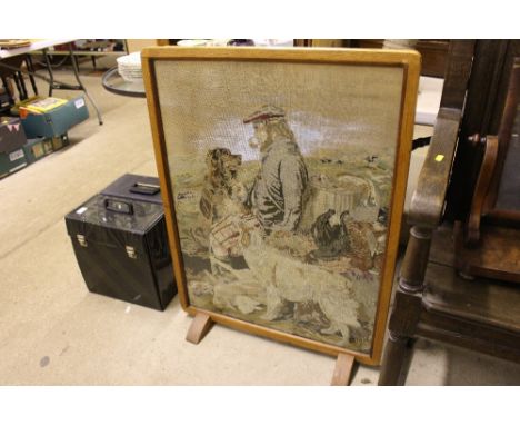 An oak framed firescreen with an embroidered panel of a scene after Landsier 