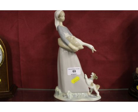 A Lladro porcelain figure of a girl with goose and dog 