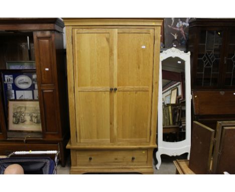 A modern light wood wardrobe fitted single drawer to base 