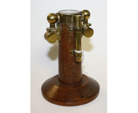An oak and brass novelty desk model, of a ship's compass, circular base, 13cm high