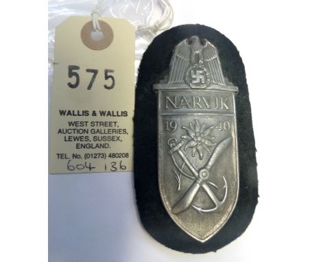 A Third Reich Narvik arm shield, of grey metal on black cloth patch with backing plate. GC     