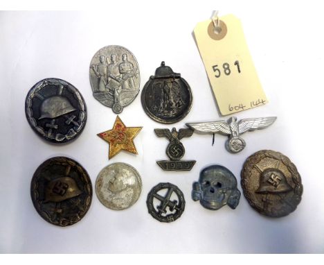 11 various Third Reich badges etc: SS grey metal cap skull; black wound badge (pin hook missing); another (swastika removed, 