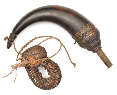 A Cambodian powder horn. Probably 19th century, 26cms, swollen top carved with lotus leaves, ribbed finial pierced for carryi