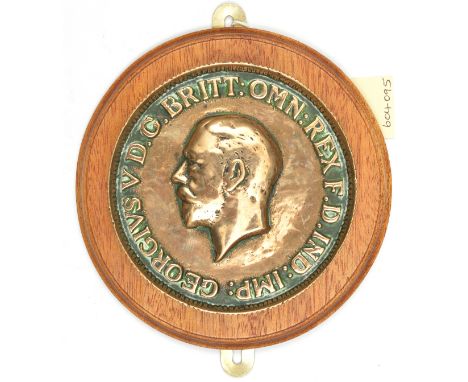 A cast brass tompion of HMS King George V, battleship 1939-50, in the form of the obverse of a milled edged Geo V coin with i
