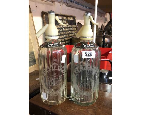A pair of vintage Schweppes soda syphons with acid etched and paper labels