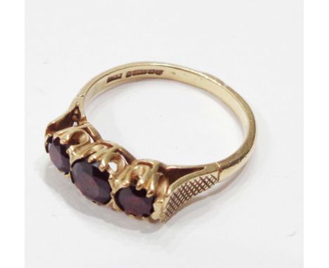 A 375 (9ct.) gold three stone garnet ring - size S