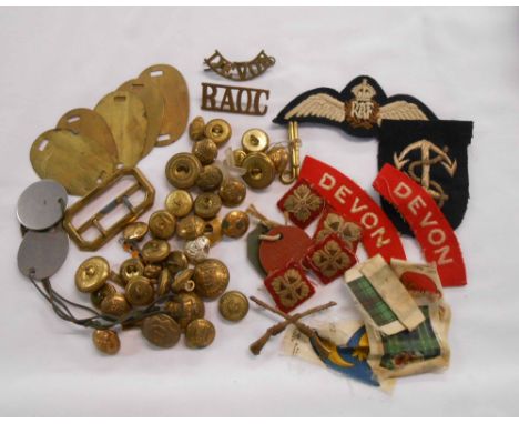 A vintage tin of military buttons, badges, patches including R.A.F. patch, Devon Regiment flashes, Royal Army Ordinance Corps