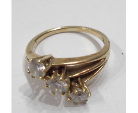 A 375 (9ct.) gold cross-over ring, set with three white paste stones - size N