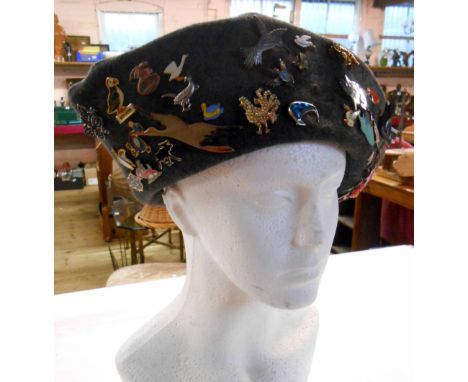 An old felt hat set with a large quantity of enamel and other bird form badges