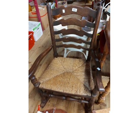 A varnished elm framed Lancashire ladder back rocking chair with woven rush seat panel, set on typical supports