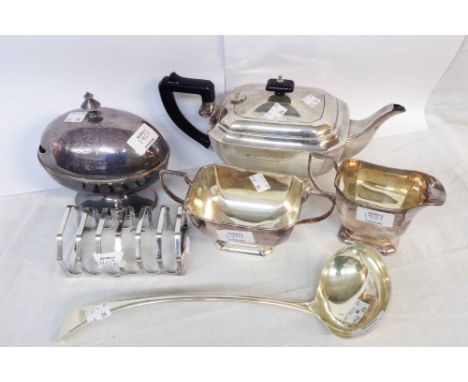 A silver plated three piece tea set - sold with a spoon warmer, large ladle and a toast rack