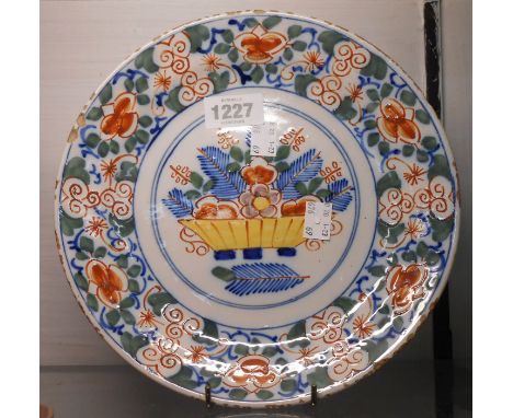 An 18th Century Dutch delft hand painted polychrome dish with central panel depicting a bowl of flowers and a floral border