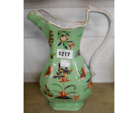 A 19th Century Ironstone jug of helmet form with transfer printed and enamel decoration on a green ground