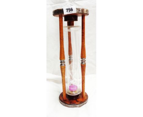 A large blown glass egg timer made from an old mechanical weaving bobbin