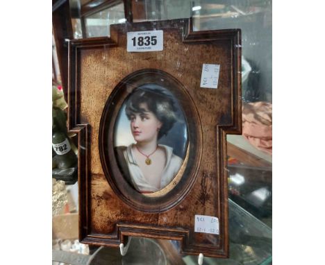 An antique German Berlin style porcelain portrait plaque, depicting the head and shoulders of a young man wearing a pendant, 