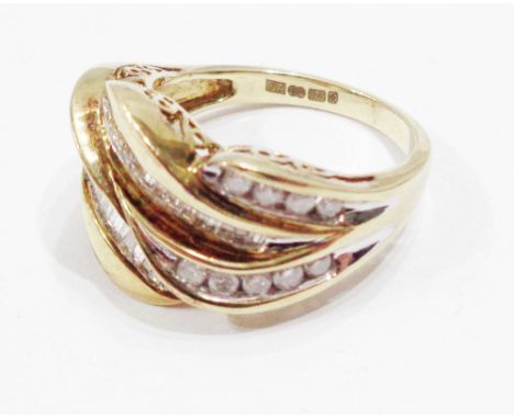 A 375 (9ct.) gold designer cross-over ring, with channel set baguette and brilliant cut small diamonds - 0.75ct. TDW - size P