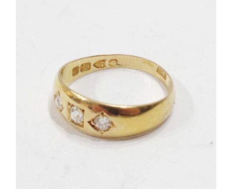 An 18ct. gold gypsy set three stone diamond ring - size P