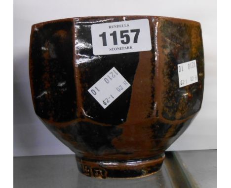 A Jeremy Leach Lowerdown pottery footed bowl of cut sided form covered in a tenmoku glaze
