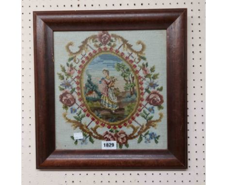 A stained wood framed woolwork panel, depicting a country girl within a decorative border