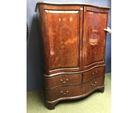 C19th mahogany Serpentine fronted linen press, fitted, a pair of doors enclosing four sliding drawers over two short drawers 