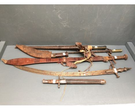 A Sudanese sword with twin groove etched blade in leather paddle shaped scabbard, a short sword with horn handle, and another
