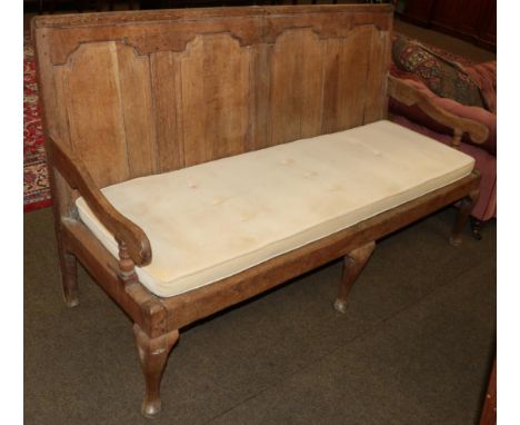 A George III joined oak panel-back settle, early 19th century, with four moulded panels above a later squab cushion and downs