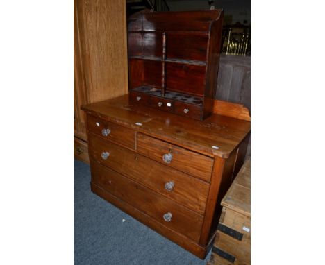 A mahogany three height chest of drawers with glass handles, together with a hanging shelf
