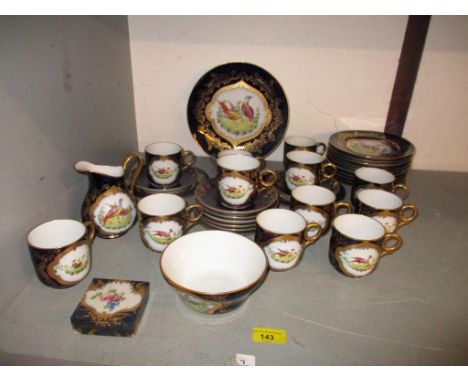 A late 19th continental, probably French porcelain tea set decorated with birds in a landscape vignette, withing a gilt work 