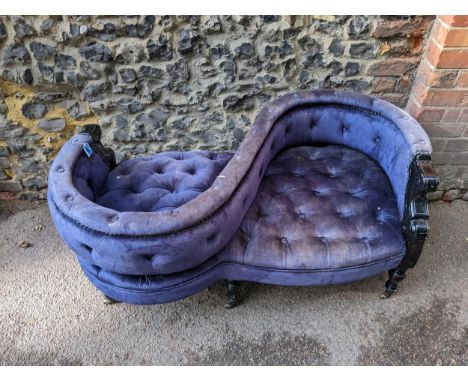 A late 20th century love seat with a black glass finished framed, button upholstered in a blue velvet fabric, on ring turned,