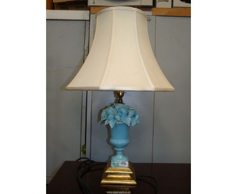A pale blue ceramic Table Lamp with square gilt base, the lamp having applied fruit and foliage to the top, (some damage), wi