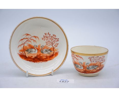 A gold rimmed antique cup and saucer hand painted with swans.