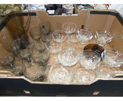 A quantity of smoky and clear glass to include: red and white wine glasses and water jug, sundae dishes, etc.