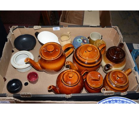 A quantity of stoneware teapots, small pots and jugs, plus black china bowl and sauce boat and painted treen lidded pot.